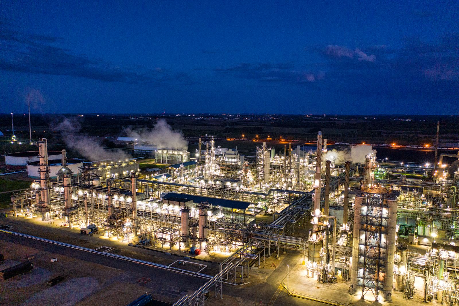 Oil and gas refinery lit up at dusk