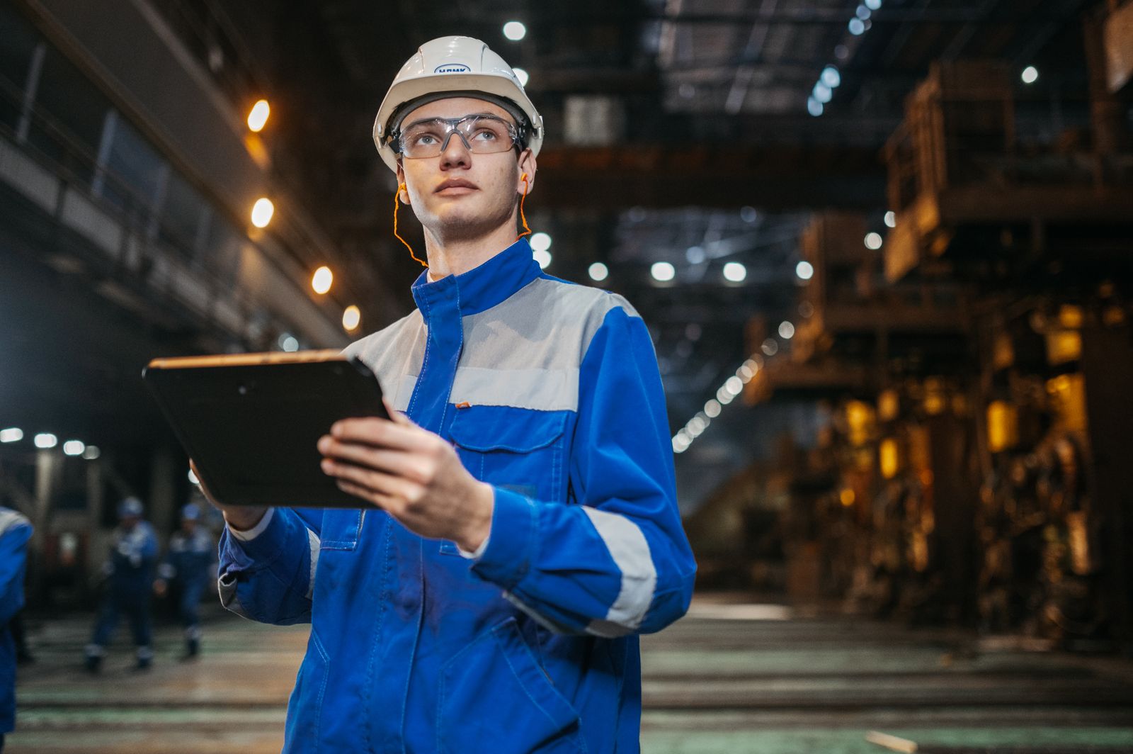 Engineer holding a tablet inside an industrial facility